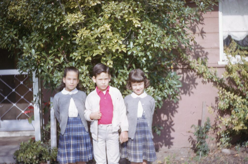 Mary, her sister and brother in St. Justin uniforms