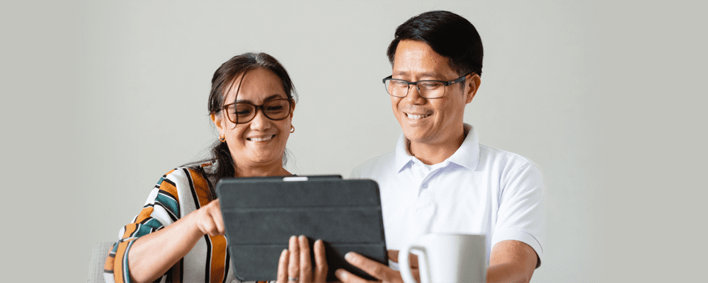 couple smiling at a tablet